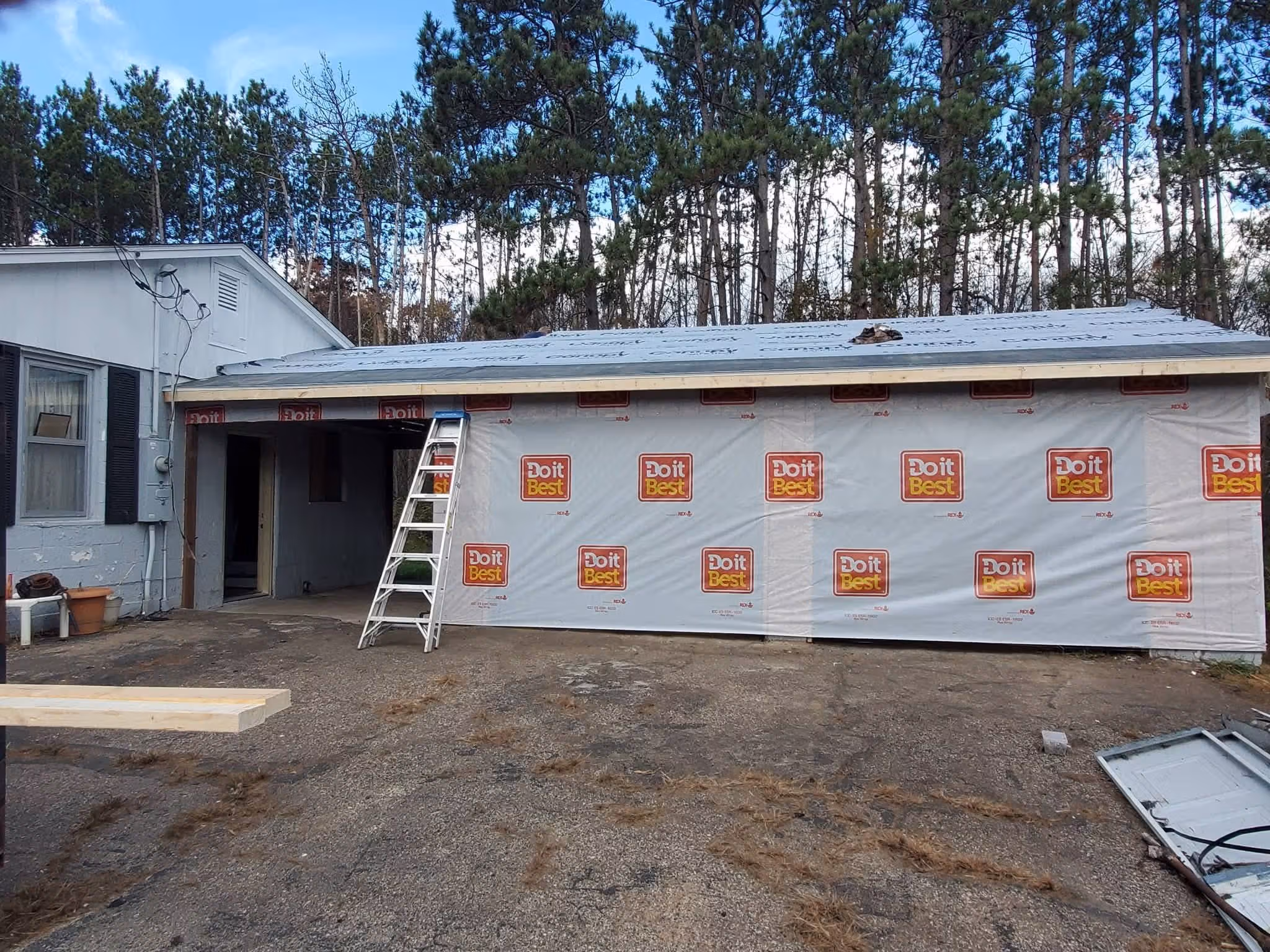 A house garage under construction with Do it Best branded sheathing and a ladder leaning on it.